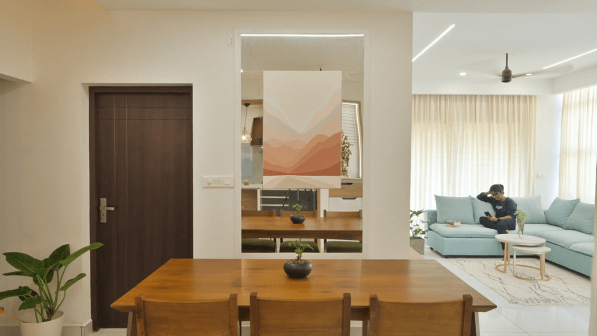 Elegant living room in a Twin Villa, showcasing a blue couch paired with a modern coffee table for a refined look.