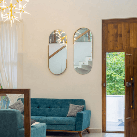 A stylish living room featuring a blue couch and a wooden door, showcasing modern interior design elements.